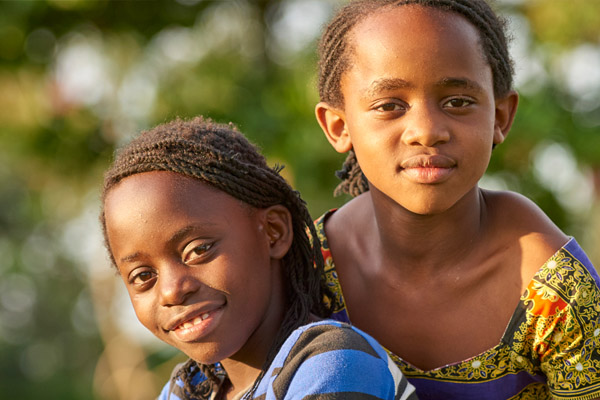 2 Mädchen in Uganda lächeln in die Kamera