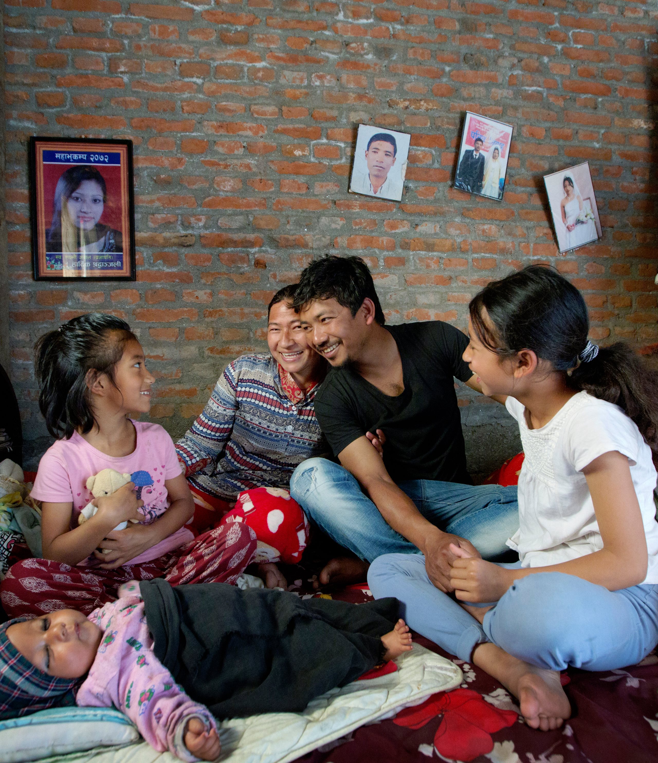 Große Familie in Nepal sitzt zusammen auf Matratze