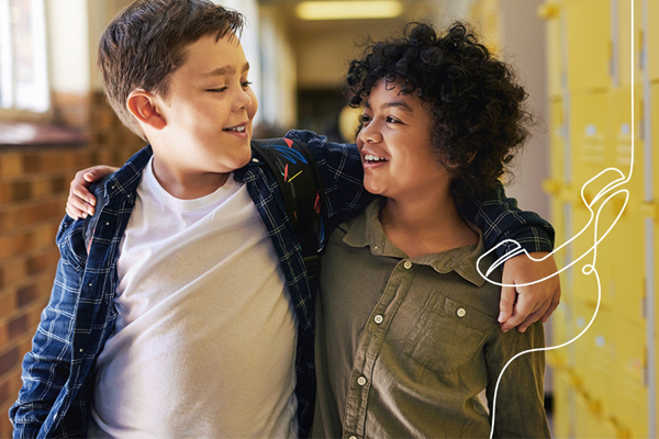 2 Jungen umarmen sich freundschaftlich am Schulgang