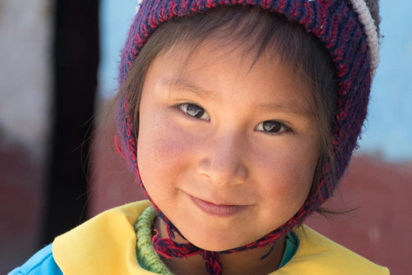 Kind aus Peru mit einer landestypischen Mütze auf dem Kopf