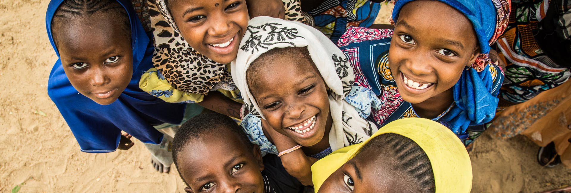 Kinder in Uganda spielen und lachen in die Kamera